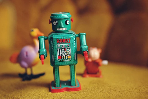 A toy robot with other small toys unfocussed on the background